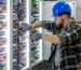 electrician-inspects-connection-working-inside-switchboard-tool-hand